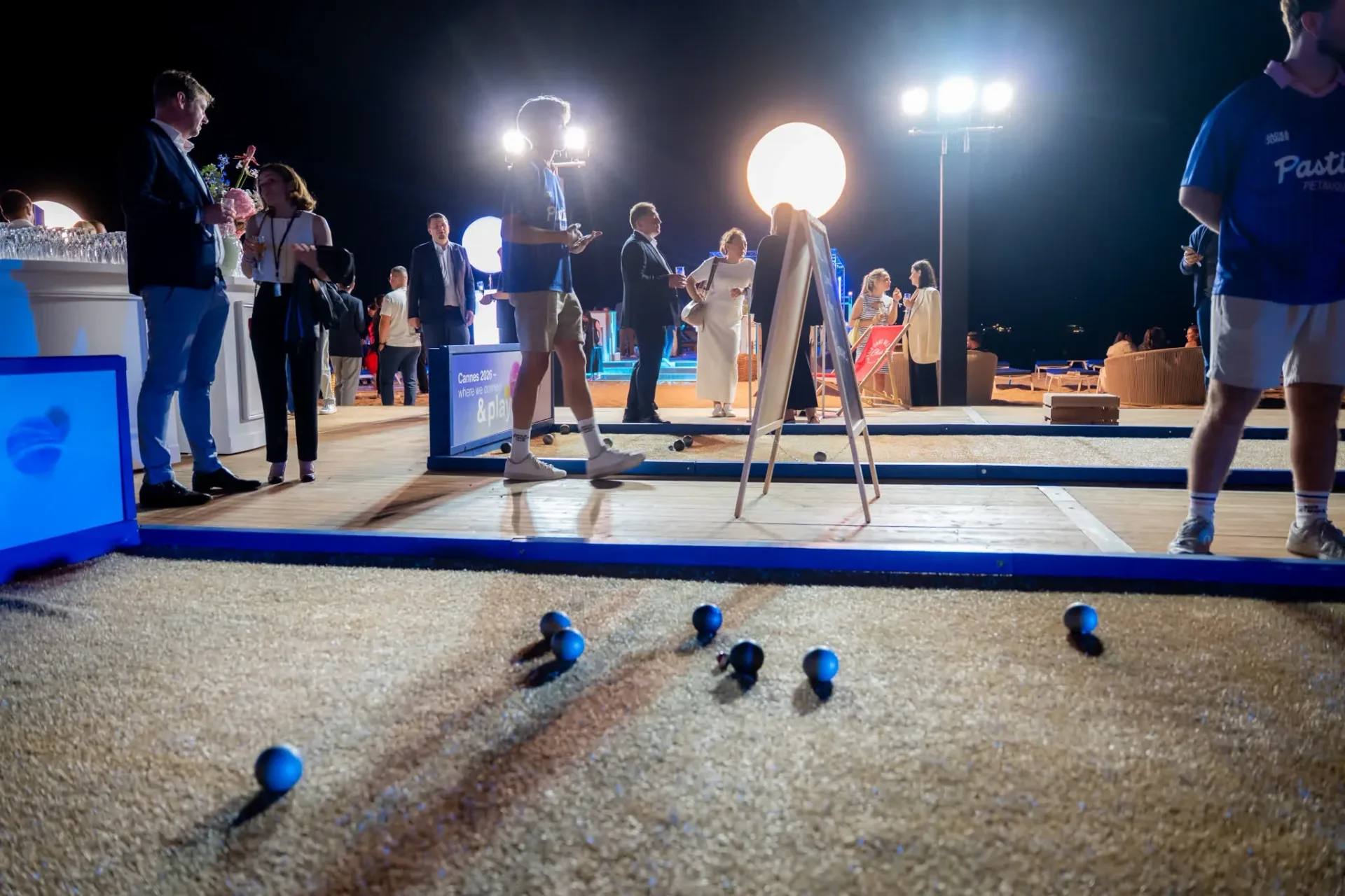 Boules on the sand of the Connect & Play court, guests mid-game at the Heinemann gala evening in Cannes.