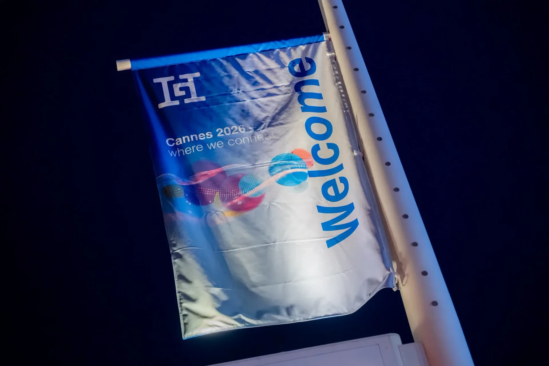 Welcome flag with the Cannes 2026 where we connect design, greeting guests at the Gebr. Heinemann gala evening on the Palais Stéphanie beach, night event photography.