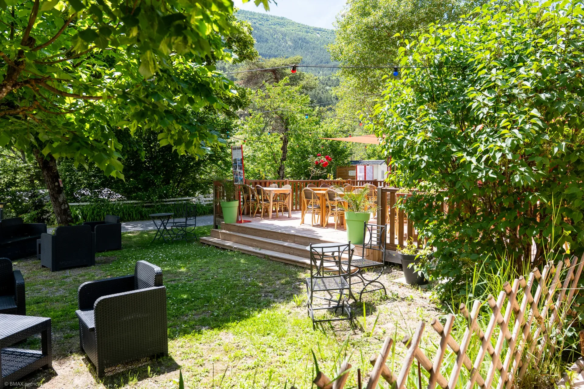 Coin détente avec fauteuils au milieu de la végétation du camping La Ribière