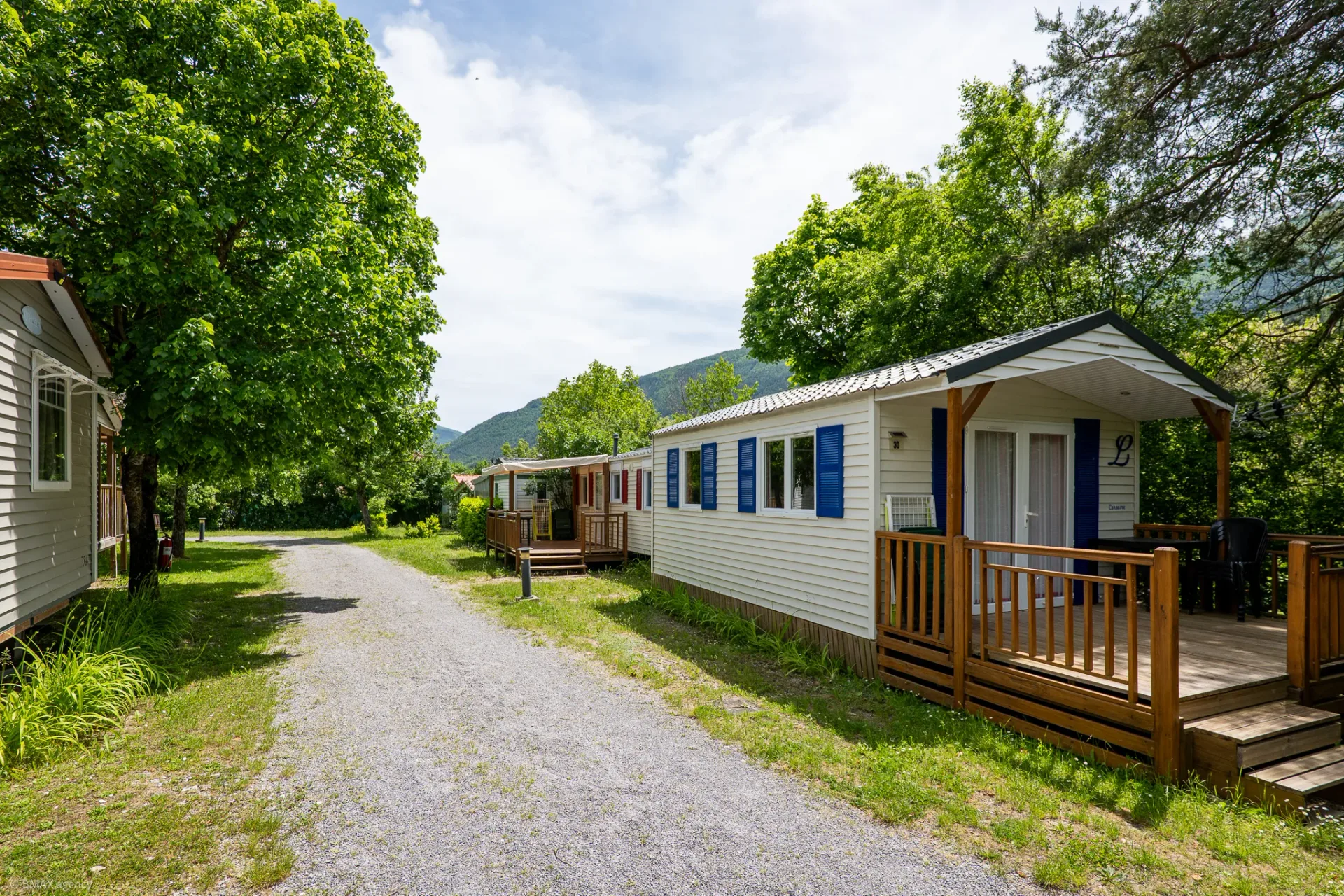 Allée du camping bordée de mobil-homes à volets bleus, La Ribière Annot