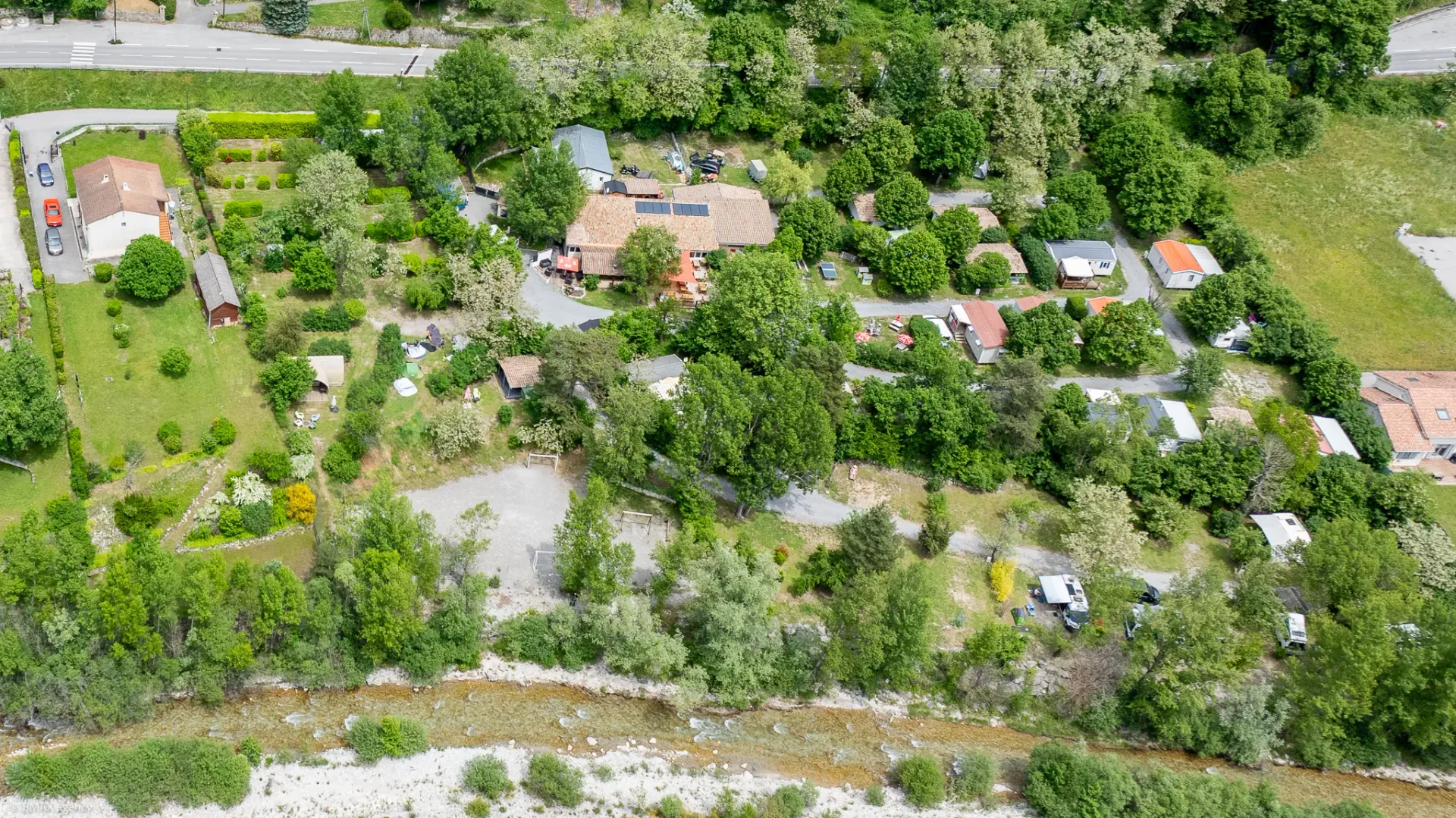 Vue aérienne du camping La Ribière à Annot entre rivière et montagnes