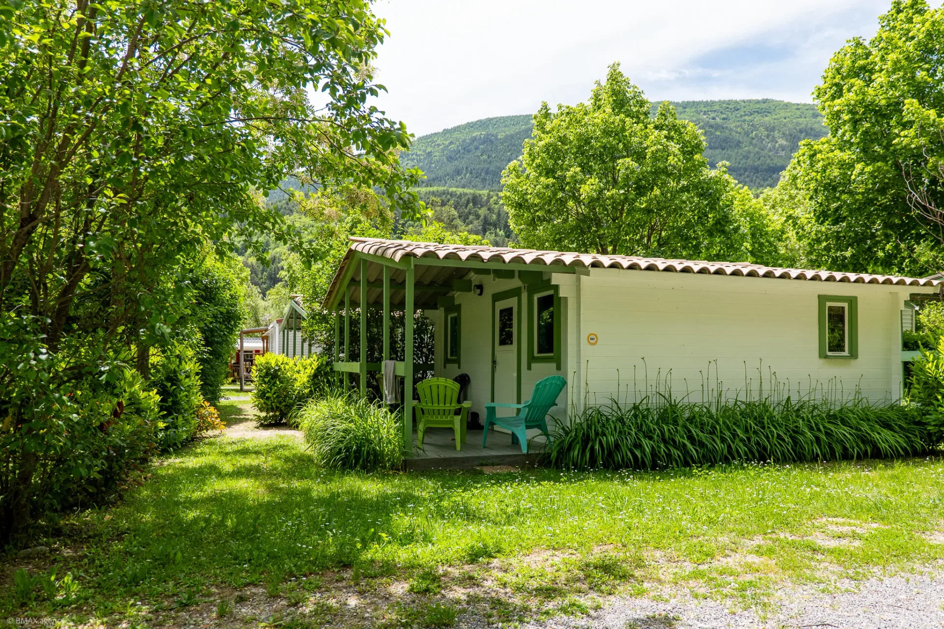 Mobil-home isolé à volets verts entouré de verdure, camping La Ribière