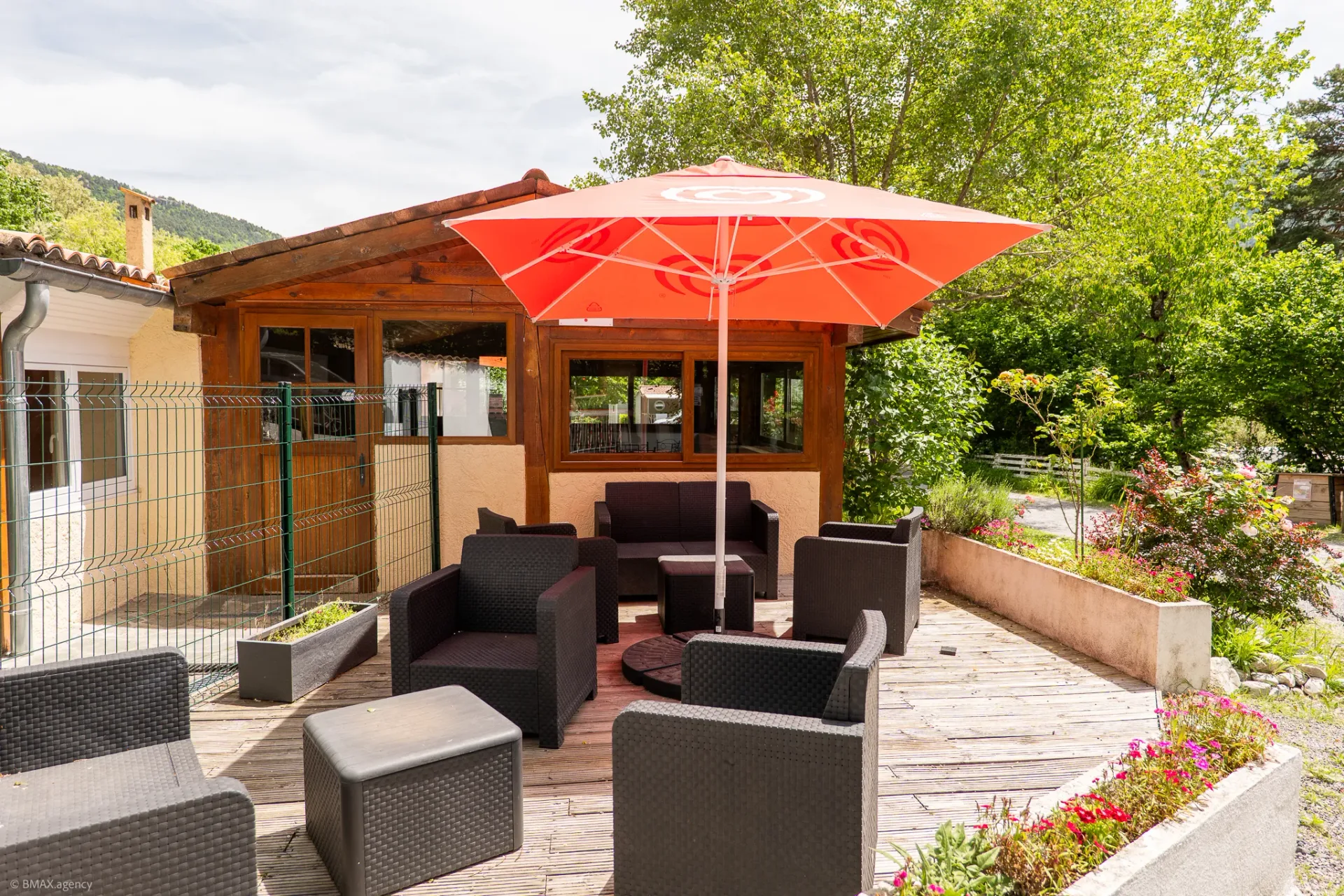 Espace lounge extérieur avec parasol et canapés au camping La Ribière